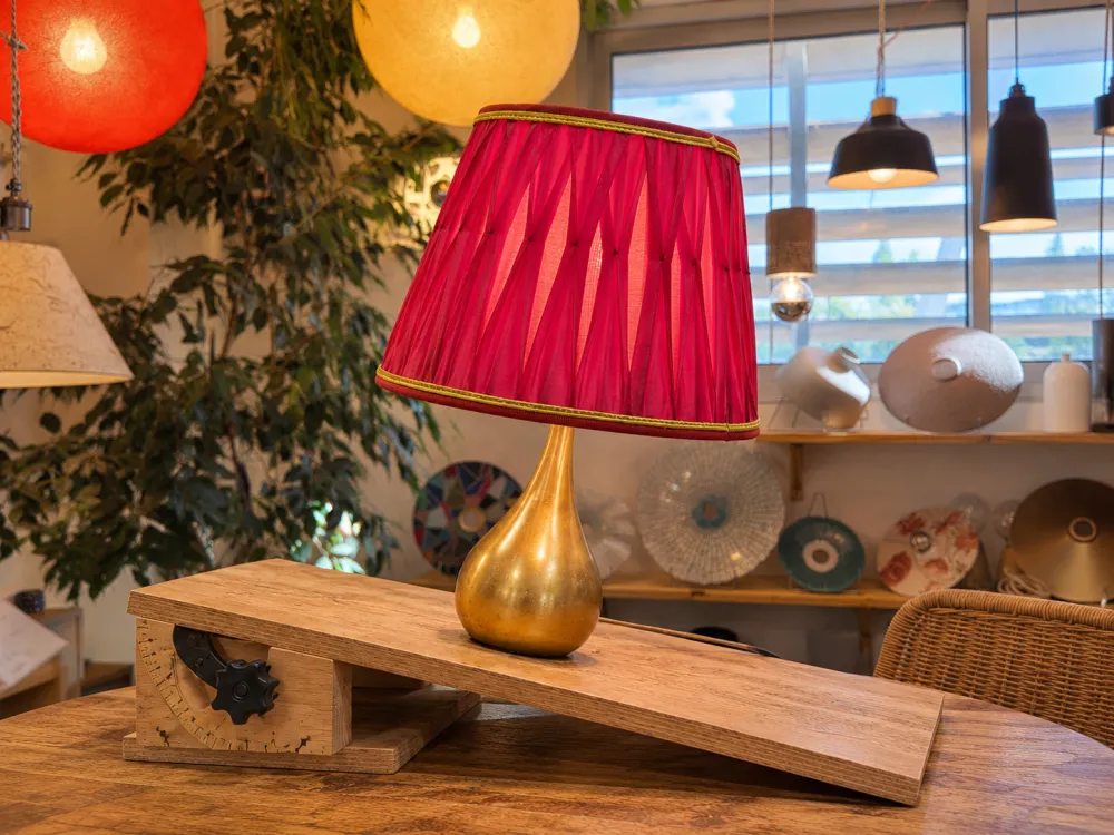 Lampe à poser placée sur un plan incliné pour l'essai de stabilité ; elle reste droite sans basculer.